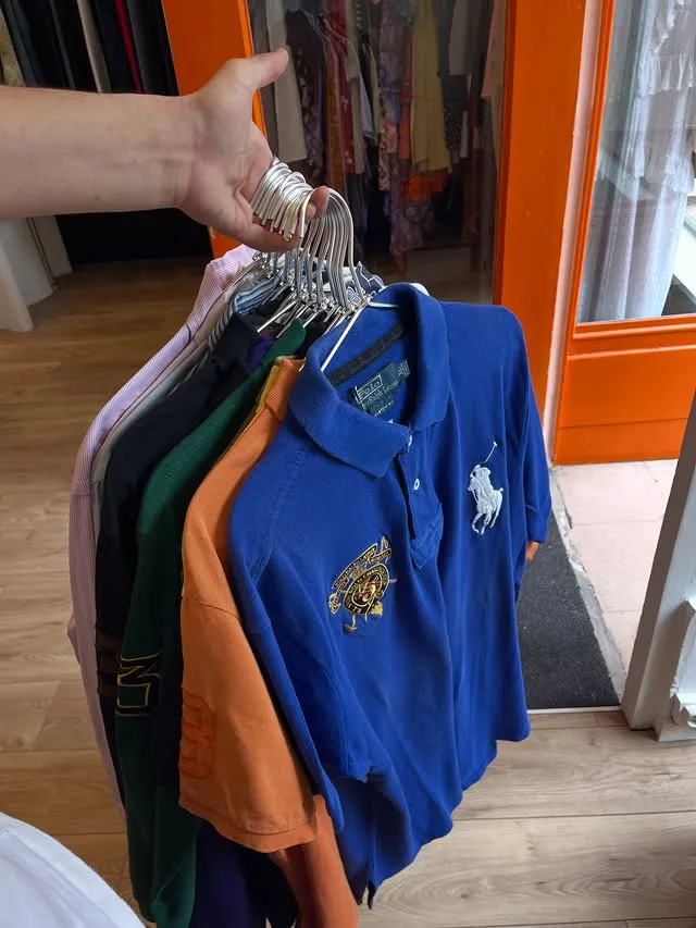 Polos Ralph Lauren tendus à bout de bras devant la vitrine