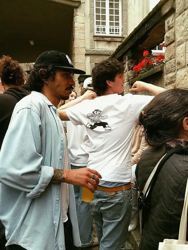 Clients réunis dans la ruelle lors de la soirée d'ouverture de la boutique