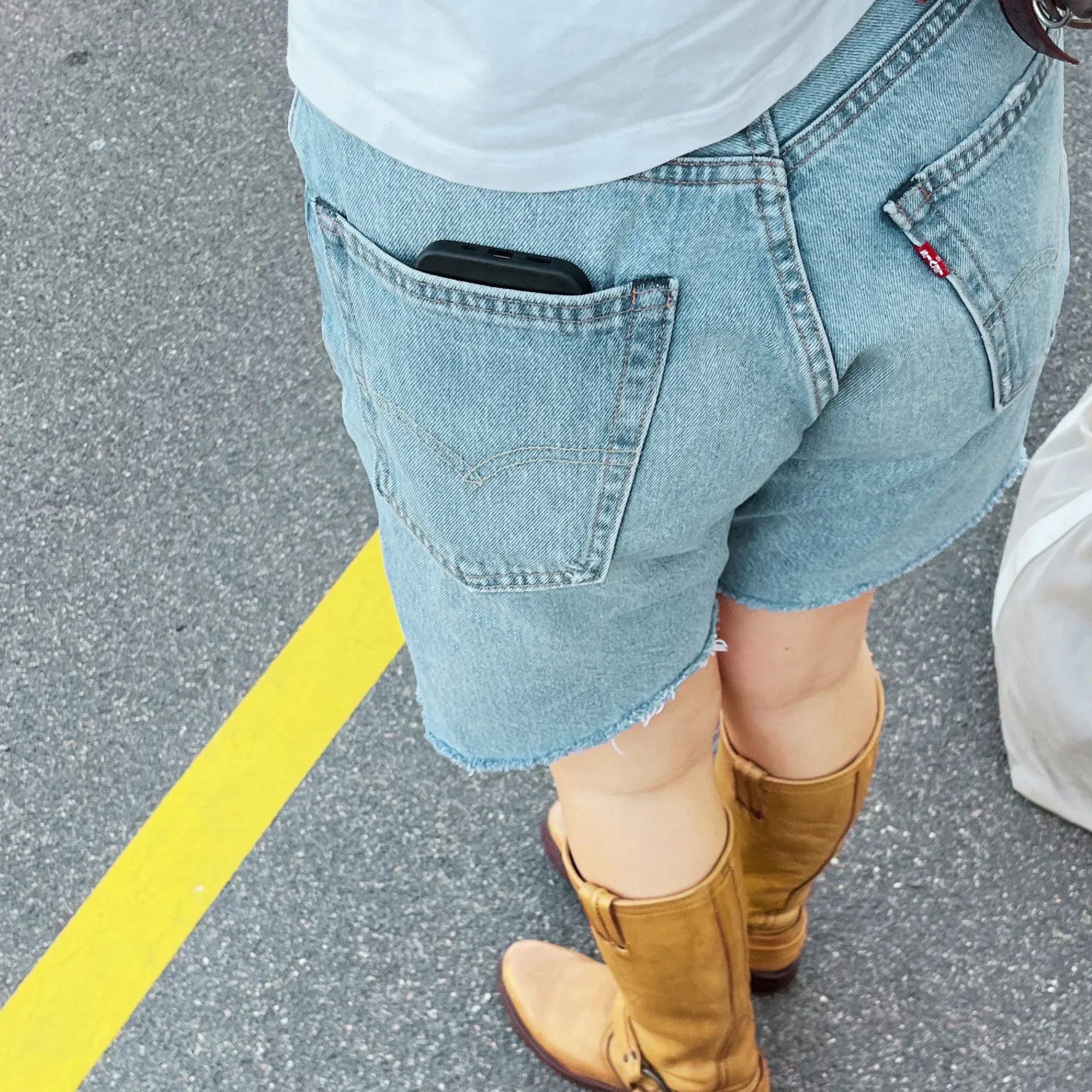 Short en jean Levi's porté avec des bottes de cuir
