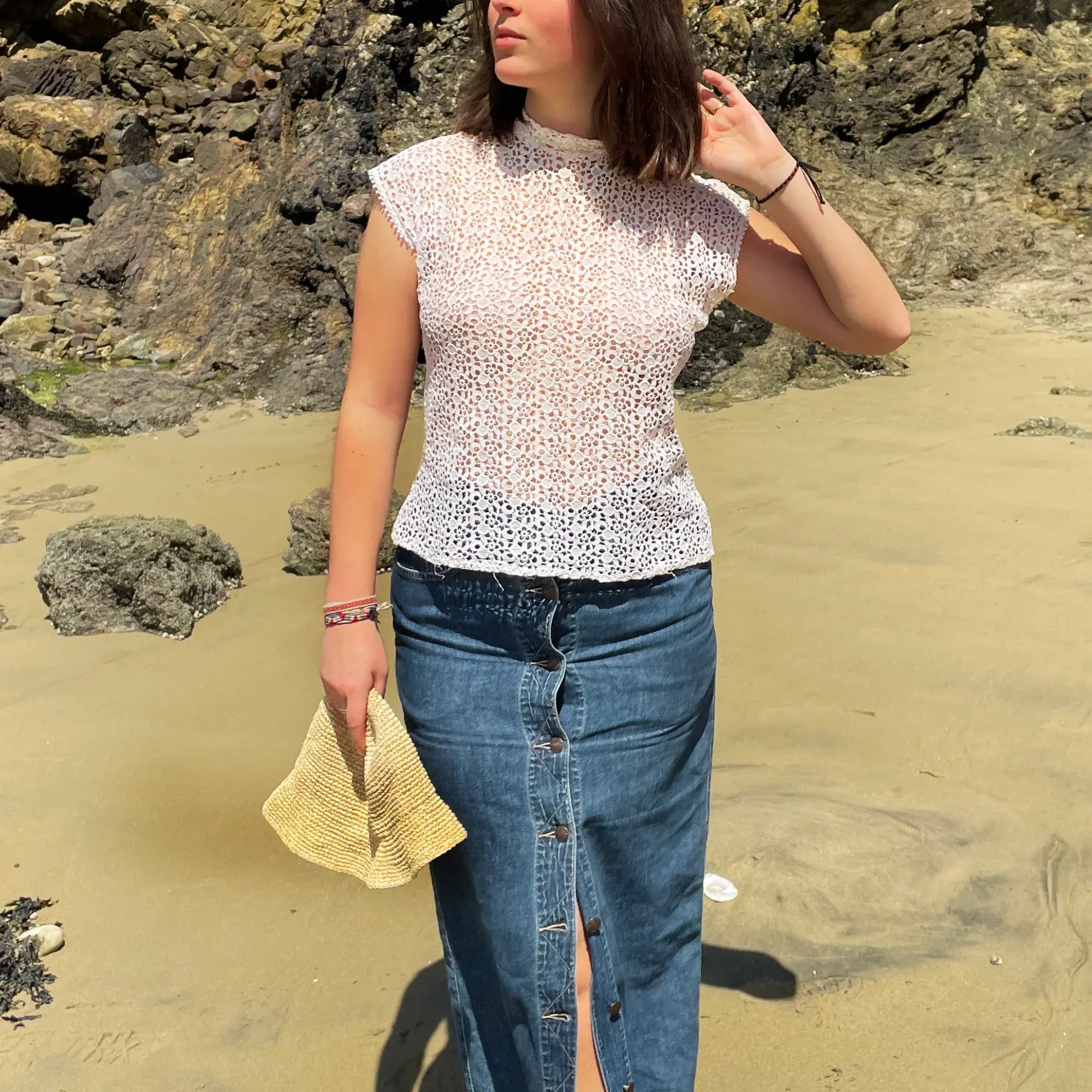 Top en dentelle blanche porté avec un jean, au bord de l'eau